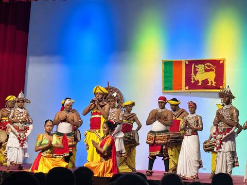 Traditional Sri Lankan cultural dance performance on a brightly lit stage.