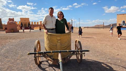 Couple poses standing inside a replica Egyptian chariot at Atlas Studios desert backlot.