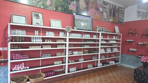 Store interior with red walls and long white shelves filled with cosmetic and wellness products.
