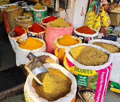 Bags overflowing with vividly coloured turmeric, chilli and other spices in a market stall