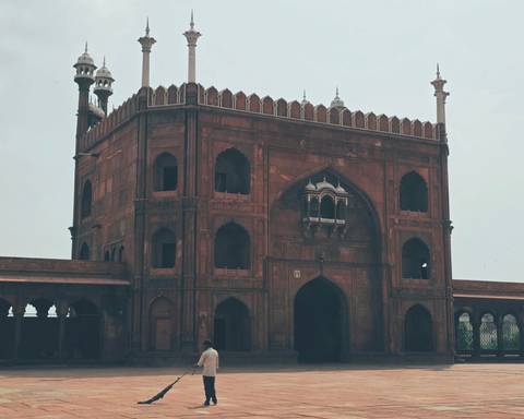 Historic red-sandstone gate of Jama Masjid featuring arched windows and slender minarets