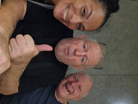 Casual selfie of three travellers laughing, one giving a thumbs-up gesture