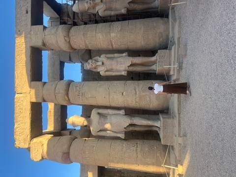 Traveller admires towering statues inside Luxor temple colonnade