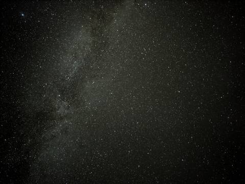 Clear night sky filled with thousands of stars and the Milky Way band stretching across.