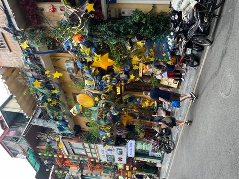 Colorful storefront covered in star decorations draws tourists and locals on a Vietnamese street.