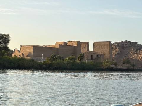 Ancient temple complex sits on an island in the Nile with warm evening light.