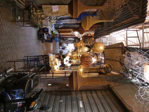 Narrow souk alley lined with ornate hanging lamps and artisans at work