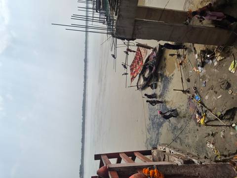 Locals washing and working on boats along the muddy banks of the Ganges River
