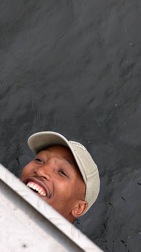 Partial selfie of a person’s face peeking into frame against dark water.