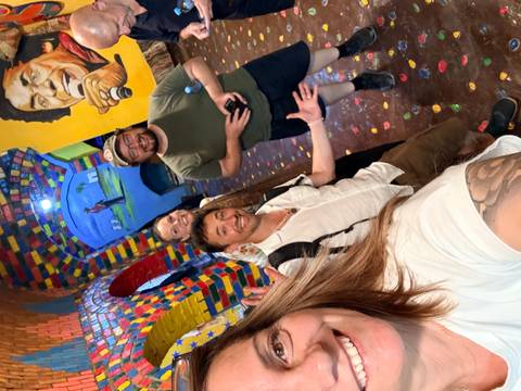 Friends posing in a brightly painted passageway adorned with colourful murals in a Nubian village.