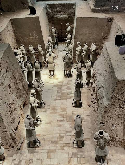 Excavation pit of the Terracotta Army with rows of headless clay soldiers standing along a tiled floor.