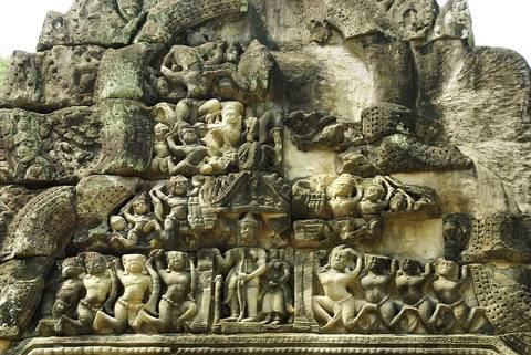 Detailed bas-relief carvings depicting mythological scenes on an ancient Khmer temple wall.