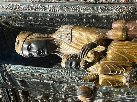 Iconic Black Madonna sculpture with child displayed behind protective glass.