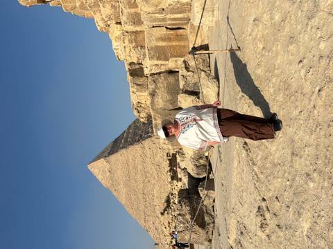 Woman posing in front of the Great Pyramid on a clear sunny afternoon.