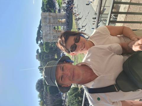 Couple selfie overlooking Rome’s Arch of Constantine and ancient ruins under a clear blue sky.