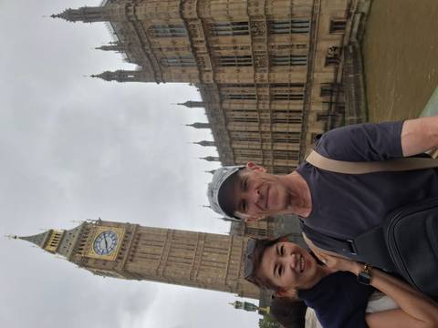 Couple selfie on Westminster Bridge with Big Ben and the Houses of Parliament on a grey day.