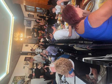 Crowded traditional Portuguese restaurant bustling with diners enjoying meals and music.