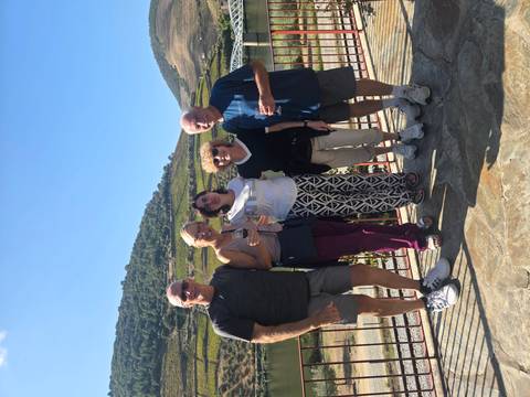 Travel companions enjoying wine with terraced Douro Valley vineyards in the background.