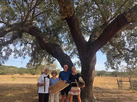 Group posing beneath a large cork oak tree in a dry rural landscape.