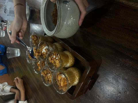 Close-up of Vietnamese egg coffee desserts topped with toasted flakes being served at a wooden table