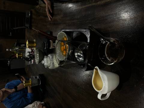 Dimly lit table set for an egg coffee workshop with bowls of yolks, tools and ingredients