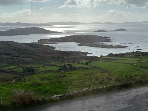 Sweeping coastal panorama of rocky peninsulas, stone-walled fields and shimmering Atlantic waters.