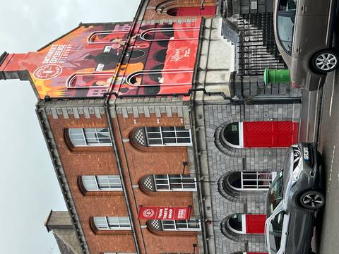 Historic Smithwick’s brewery building with colorful mural and red doors on a city street.
