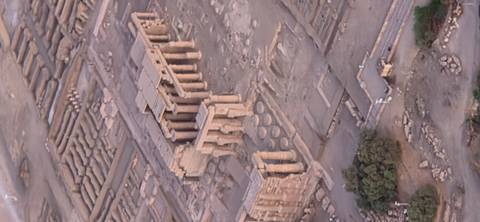 Slightly soft aerial view of a large temple complex and surrounding excavations in the desert taken from a hot-air balloon.