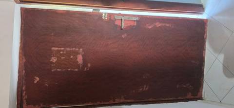 Full wooden door with peeling and scratched paint revealing underlying layers.