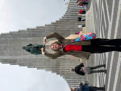 Visitor poses holding up the Leif Erikson statue in front of Reykjavik’s Hallgrimskirkja church.
