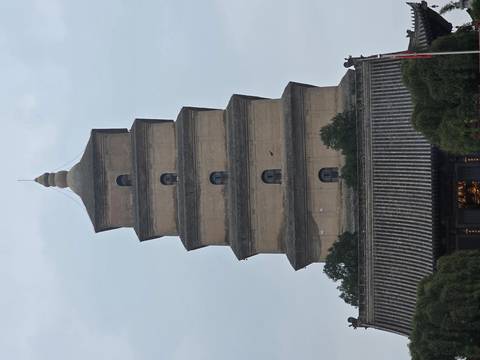 Straight-on view of the tiered brick Big Wild Goose Pagoda rising against a pale sky.