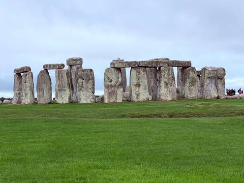 The prehistoric stone circles of Stonehenge stand stark against an overcast sky.