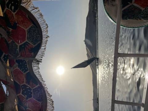 Traditional felucca sails gracefully on the Nile at sunset with sparkling water reflections.