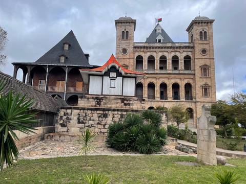 Historic royal palace complex built of stone with steep roofs under a cloudy sky in Antananarivo.