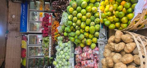 Colorful market stall stacked high with fresh tropical fruits including mangoes and dragon fruit.