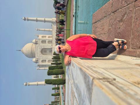 Traveller posing in front of the iconic white marble Taj Mahal on a clear day.