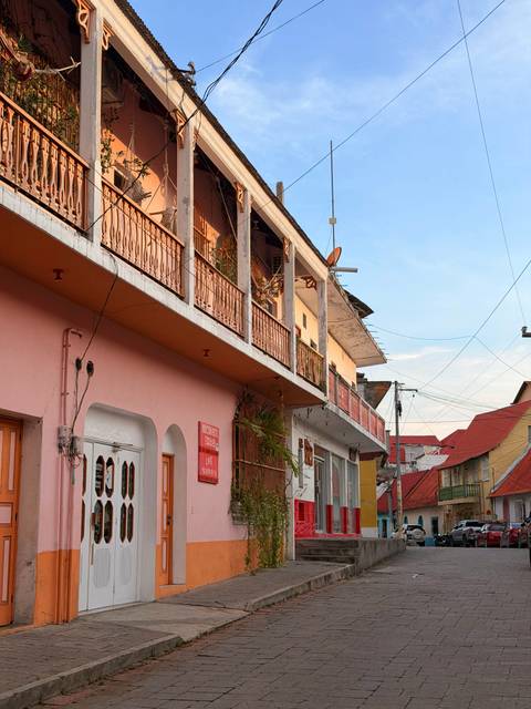 Colorful low-rise street buildings with balconies at golden light in a lakeside town.