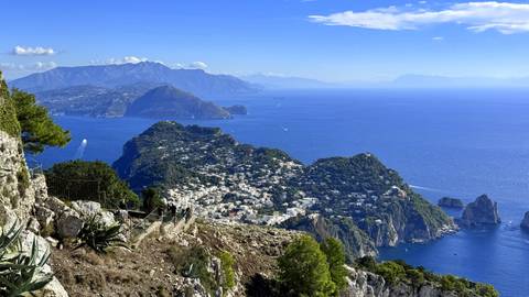High viewpoint over Capri town and dramatic coastline against deep-blue Tyrrhenian Sea.