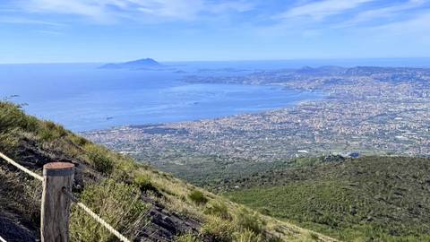 Sweeping view from Mount Vesuvius rim across the Bay of Naples and cityscape below.