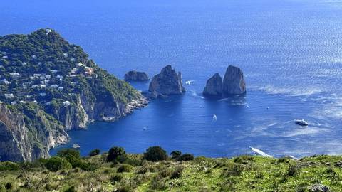 Faraglioni sea stacks rise from turquoise waters off Capri’s rugged coast.