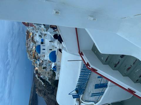Blue-domed churches and whitewashed houses of Oia terraces glow in the evening light.