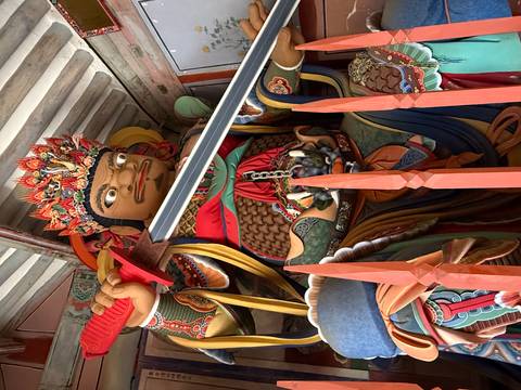 Vibrant guardian deity statue wielding a sword inside a Korean temple hall