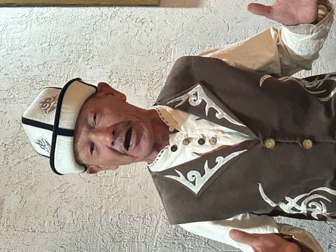 Portrait of an elderly man wearing a traditional Kyrgyz felt hat and embroidered vest.