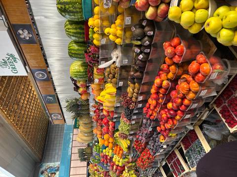 Abundant display of fresh fruit and produce inside an indoor market.