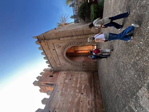 Visitors walk toward the grand arched entrance of an ancient Moroccan fortress