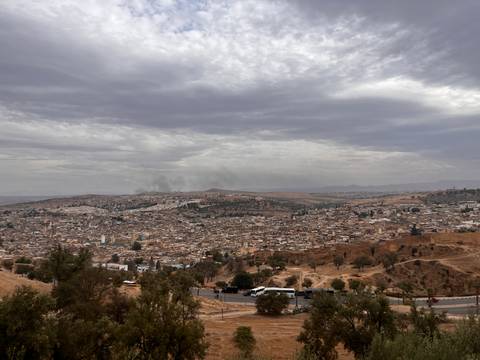 Wide panorama of Fes city sprawled beneath a dramatic overcast sky