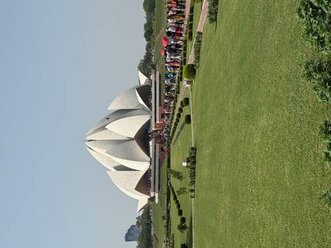 Lotus Temple's white petal-shaped structure rising above manicured lawns with a long queue of visitors.