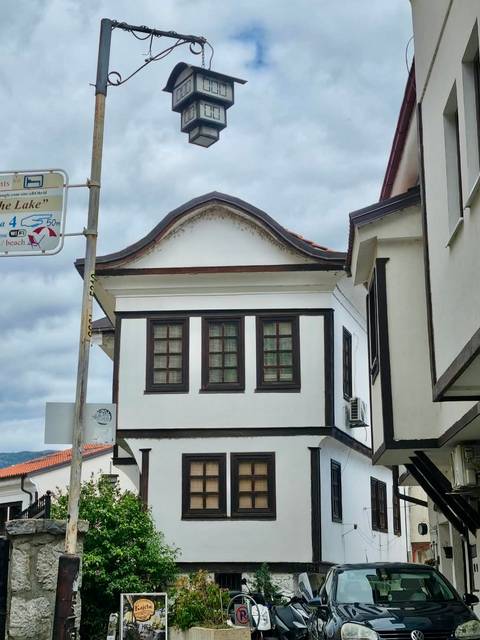 Traditional white-walled Ottoman-style house with dark wood trim under a cloudy sky in Ohrid.