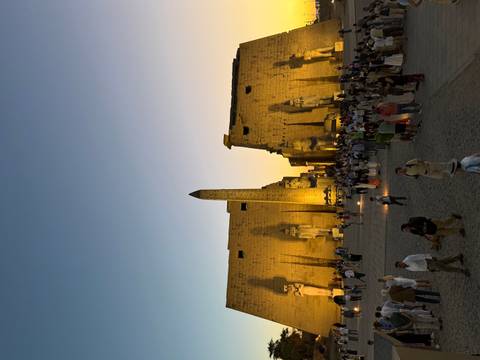 Evening crowds gather at the illuminated pylons and statues of Luxor Temple.