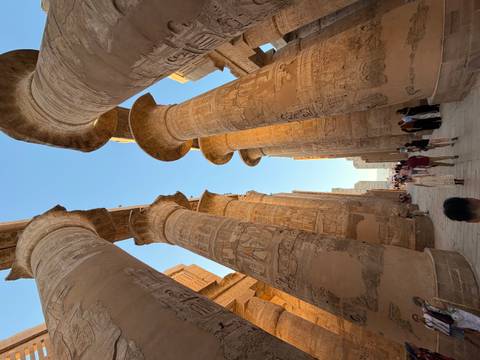 Visitors walk among the towering hieroglyph-covered columns of Karnak Temple in Luxor.